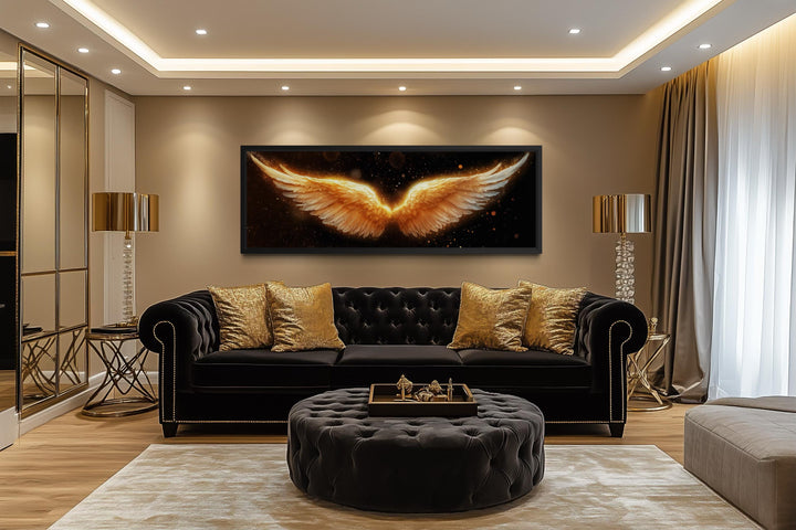 Horizontal canvas print of glowing golden angel wings on a black background in a luxury living room.