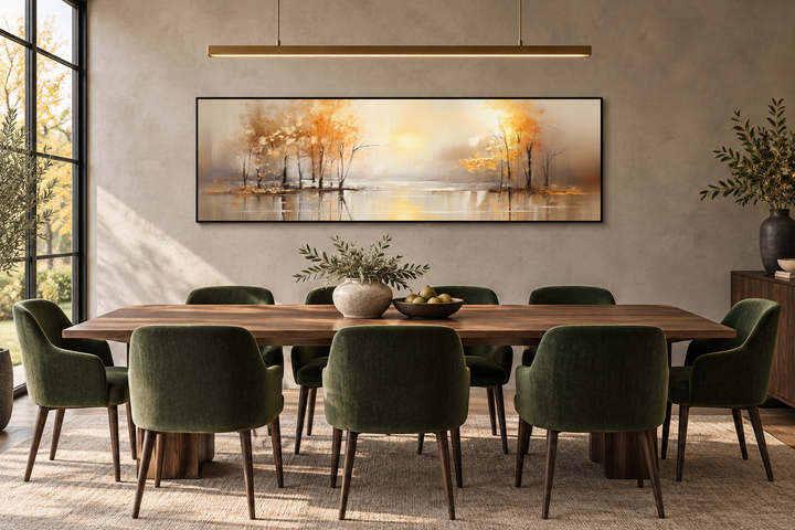 Long horizontal wall art of golden autumn trees reflecting on a lake above a dining table.
