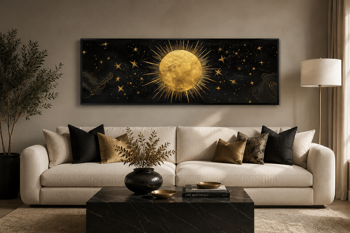 Golden sun and stars on a long horizontal black canvas wall art above a white sofa.