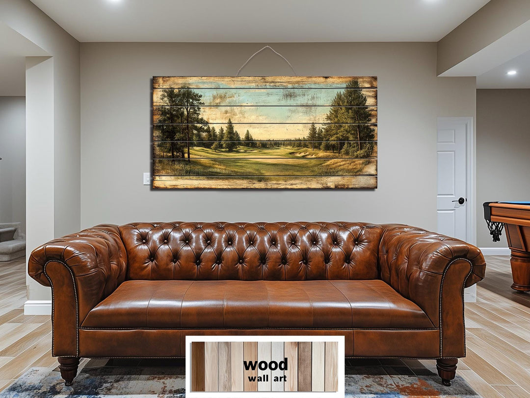 A panoramic golf course scene printed on distressed wood planks hangs above a brown leather sofa.