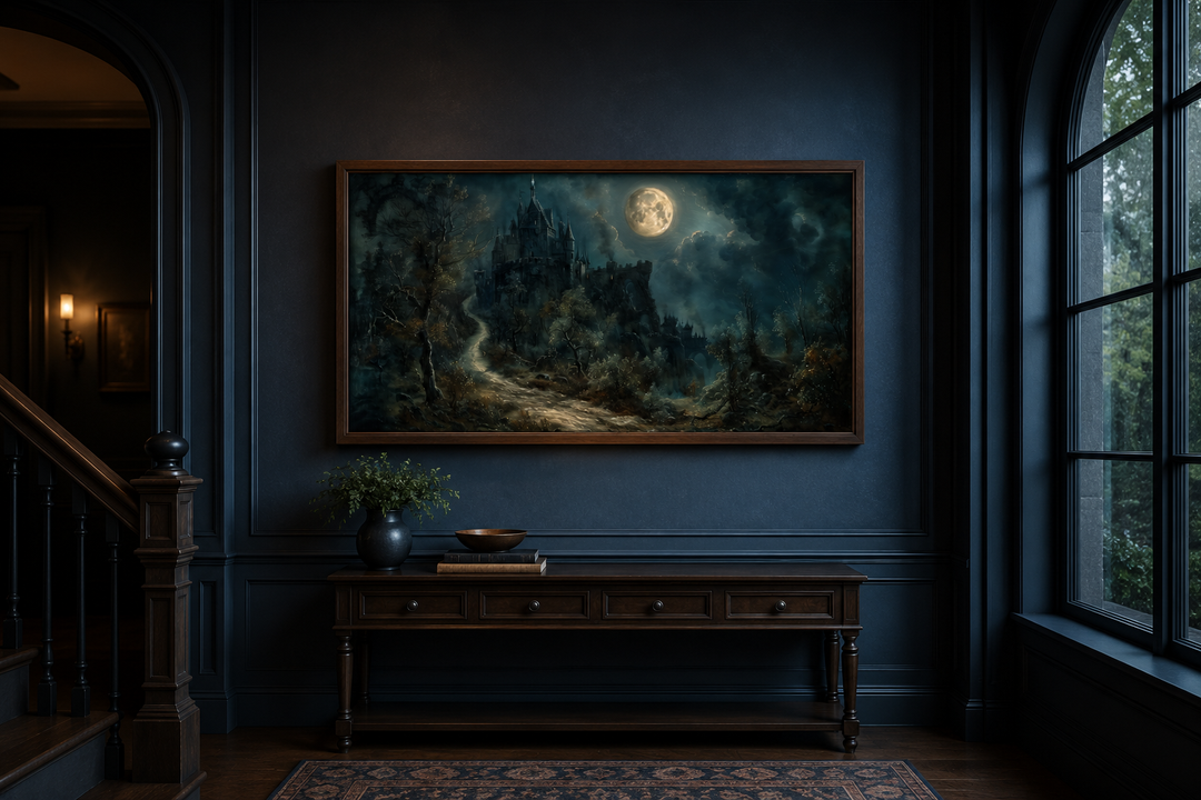 Framed canvas of a gothic castle under a full moon, hung above a dark wood console table.