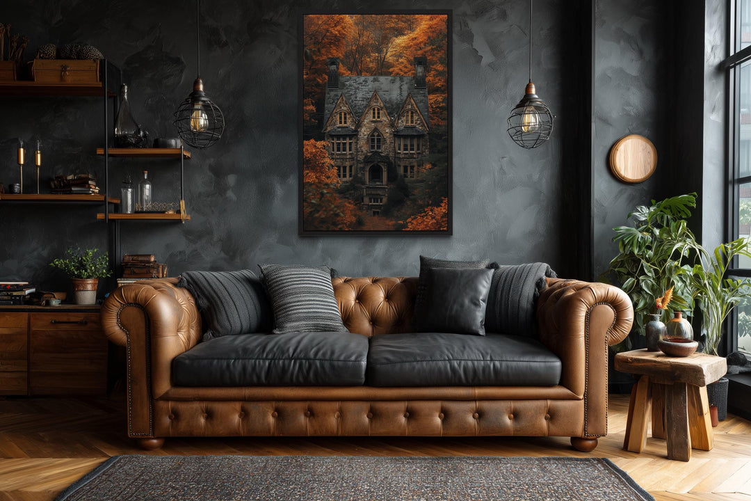 Gothic haunted house canvas art above a brown leather sofa in a dark academia style room.