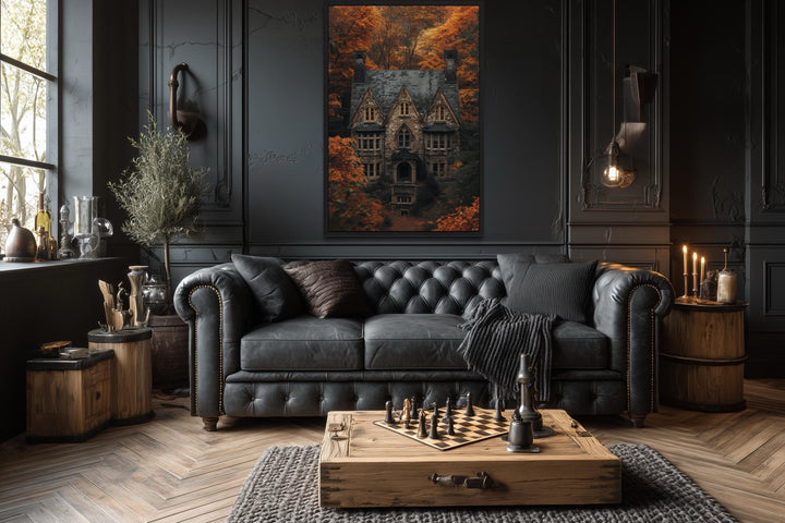 Gothic haunted house canvas art in a dark academia living room above a black leather sofa.