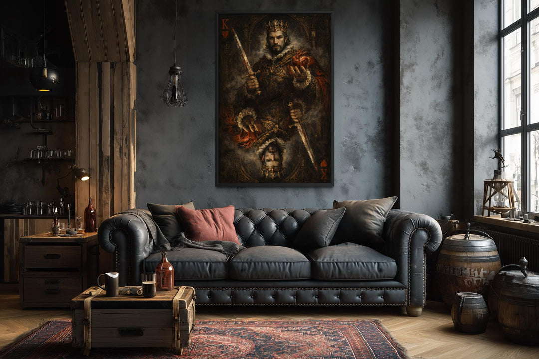 Gothic King of Hearts canvas print hanging above a dark leather sofa in a moody, rustic room.