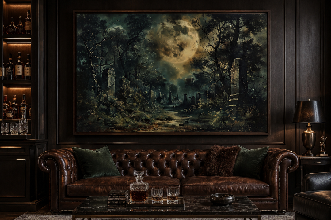 Framed canvas wall art of a haunted cemetery under a full moon above a brown leather sofa.