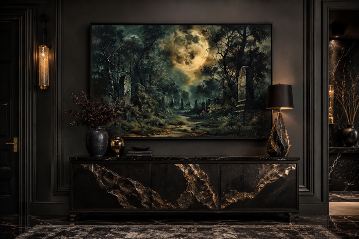 Framed canvas wall art of a haunted cemetery under a large full moon in a dark, gothic room.