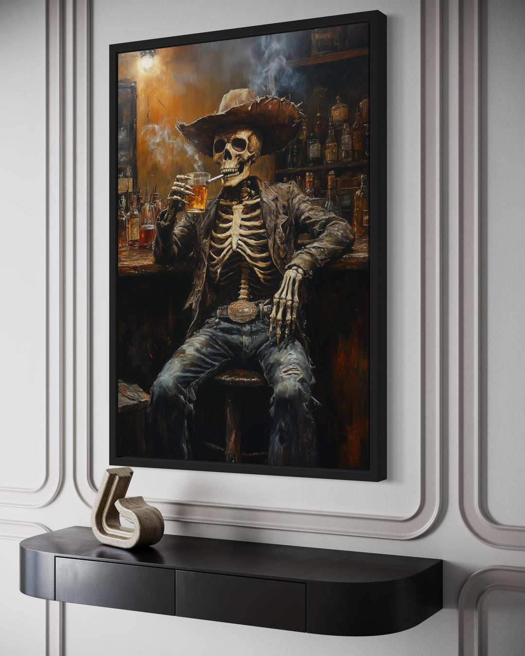 Framed wall art of a skeleton cowboy smoking a cigar and drinking beer in a rustic Western bar.