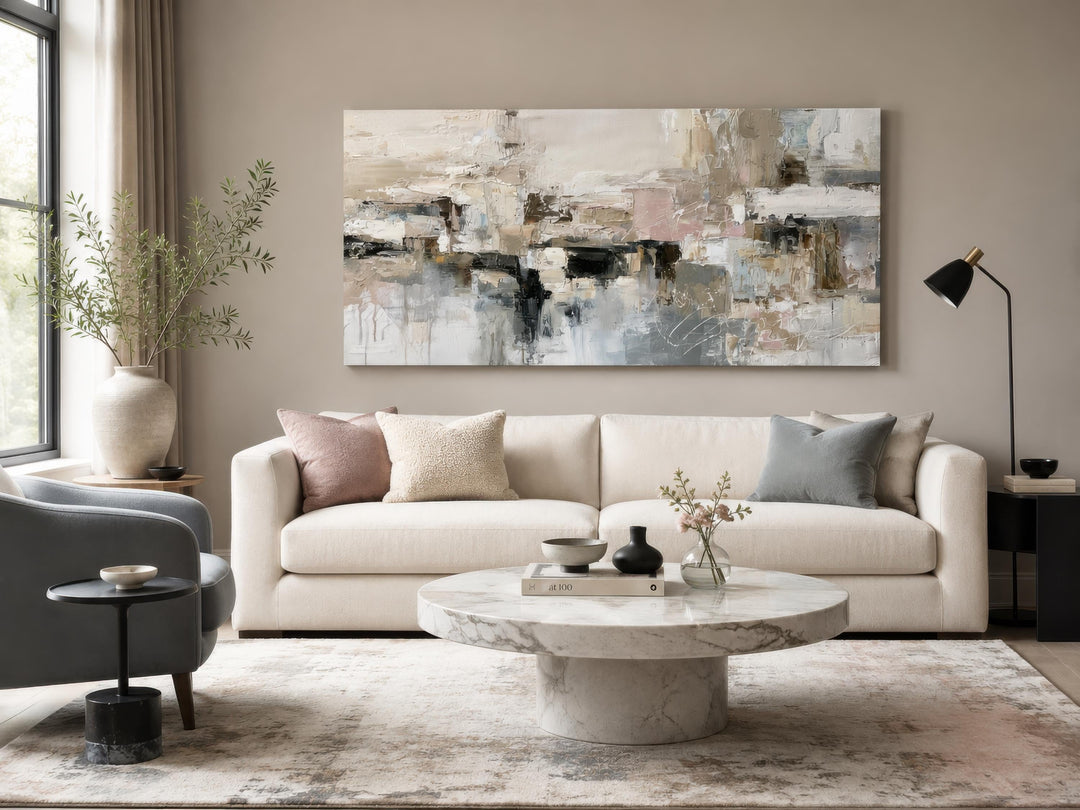 Horizontal abstract canvas print with gray, beige, and blush brushstrokes above a white sofa.
