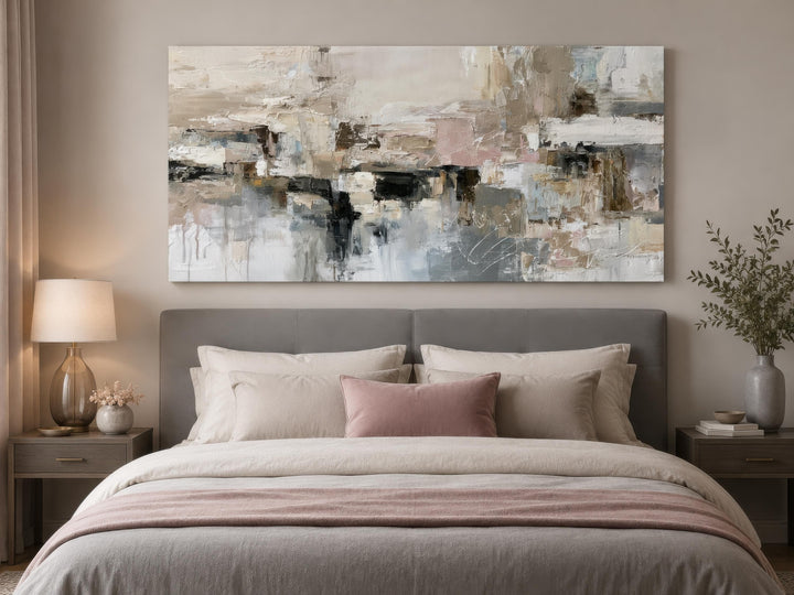 Horizontal abstract canvas print with gray, beige, and blush brushstrokes above a bed.