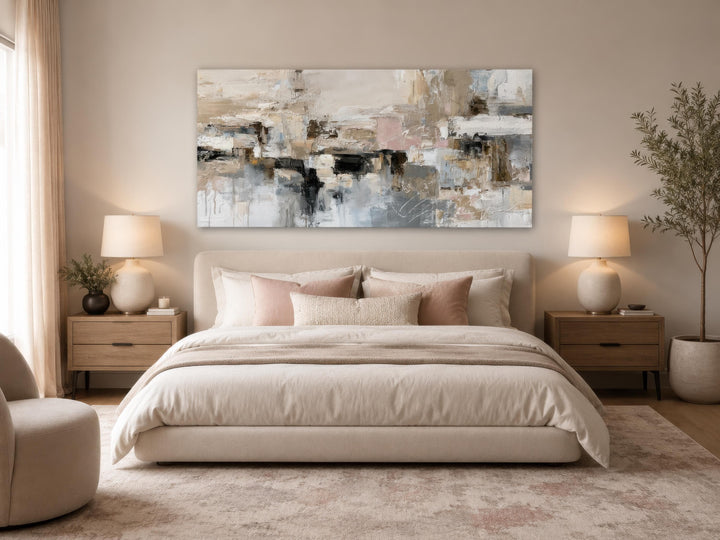 Gray, beige, and blush neutral abstract horizontal canvas print hanging above a bed in a bedroom.