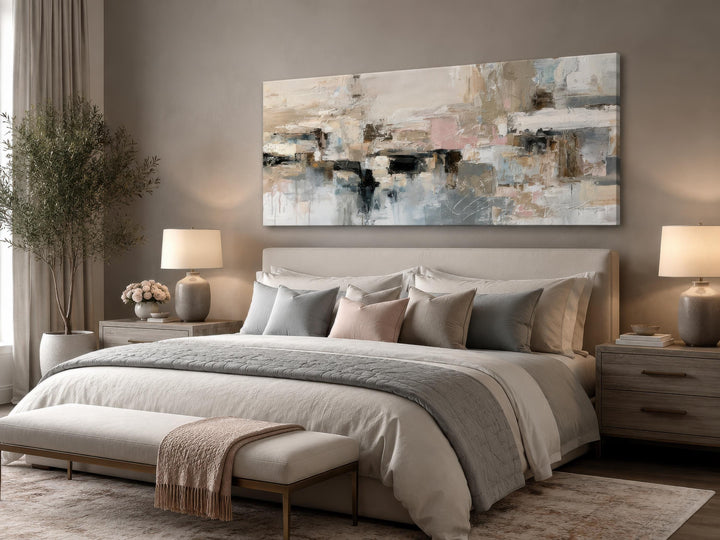 Horizontal abstract canvas print with gray, beige, and blush tones hung above a bed.