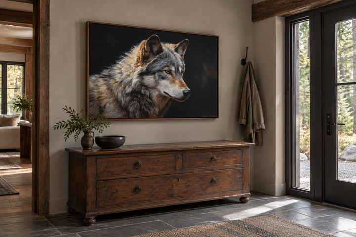 Grey wolf portrait framed canvas wall art hanging above a rustic wooden dresser in a cabin entryway.
