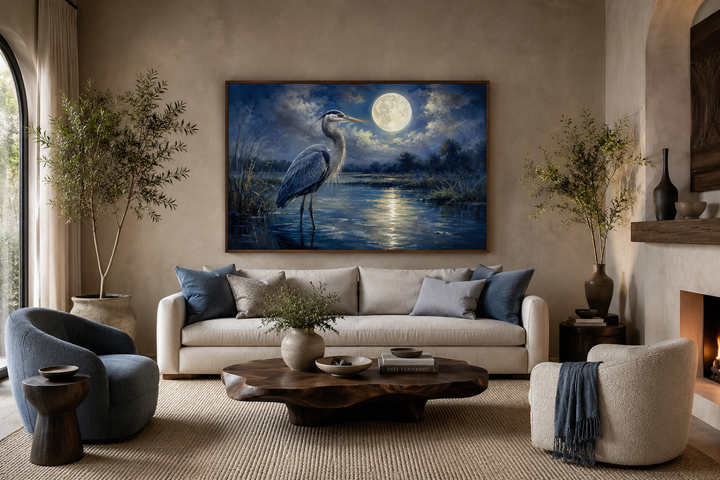 Great Blue Heron and full moon at night framed canvas wall art above a neutral sofa.
