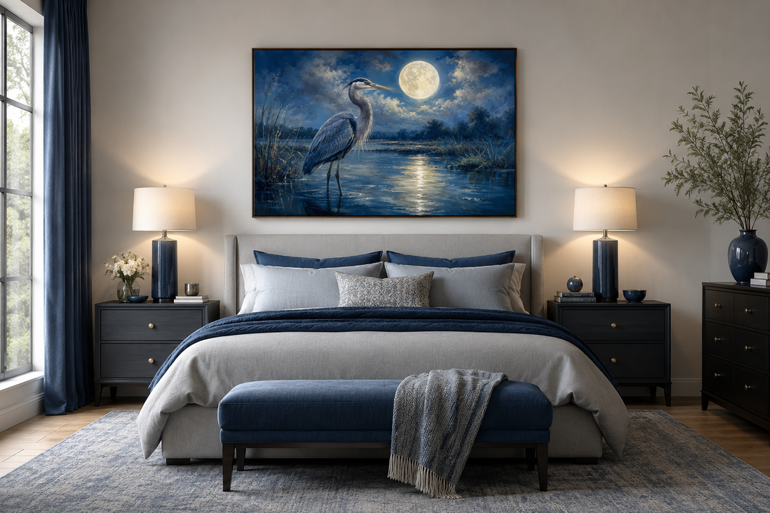 Great Blue Heron and full moon framed canvas wall art hanging above a bed in a blue-toned bedroom.