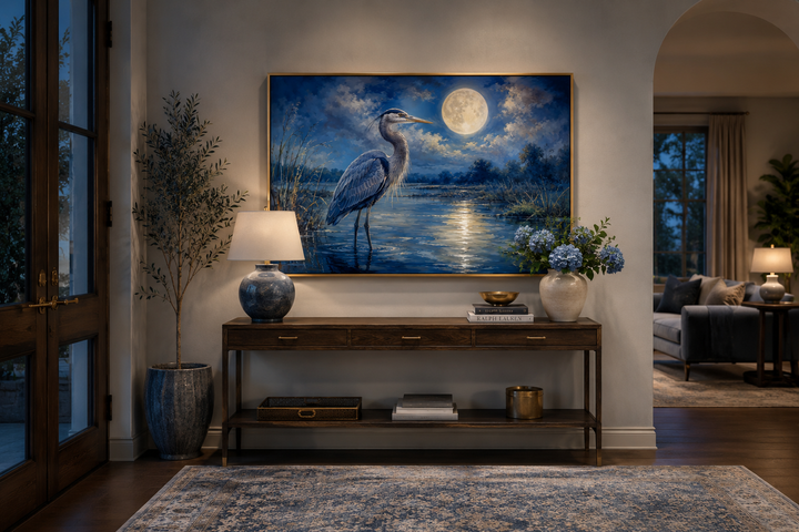 Great Blue Heron and full moon framed canvas wall art above a wooden console table in a living room.