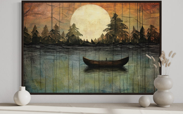 Framed canvas wall art of a boat on a lake under a large full moon with a forest silhouette.