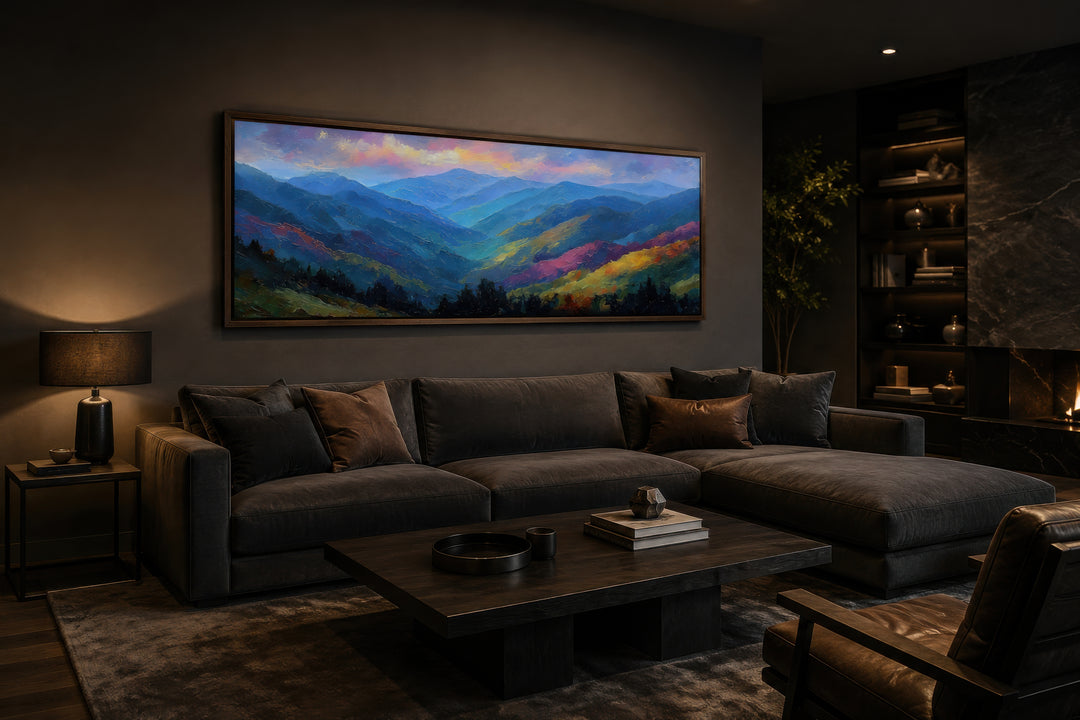 Panoramic canvas wall art of the Great Smoky Mountains at sunset above a dark sofa in a living room.