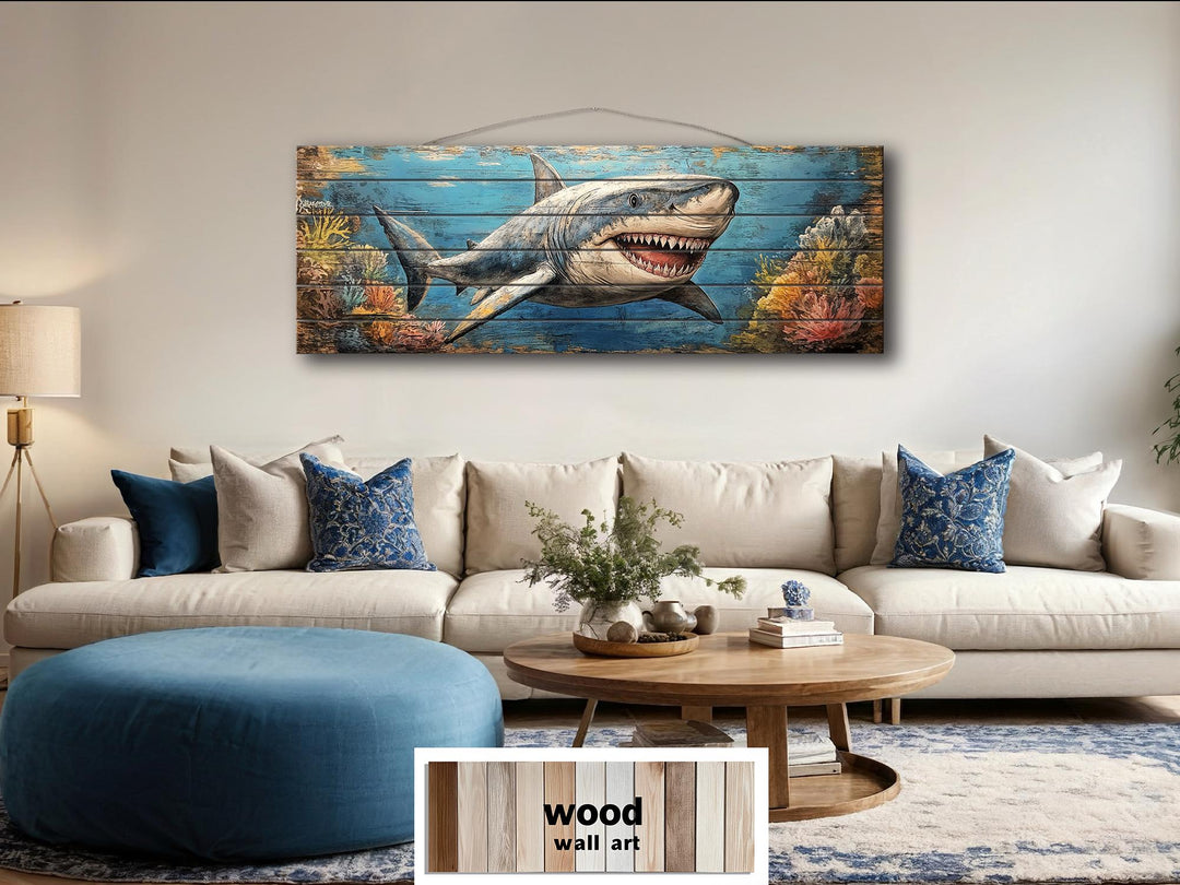 A horizontal distressed wood wall art piece featuring a great white shark swimming through a reef.