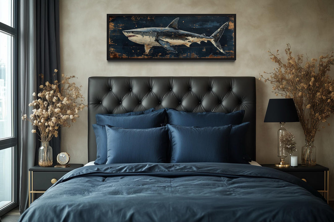 Great white shark horizontal canvas wall art above a black tufted headboard in a masculine bedroom.