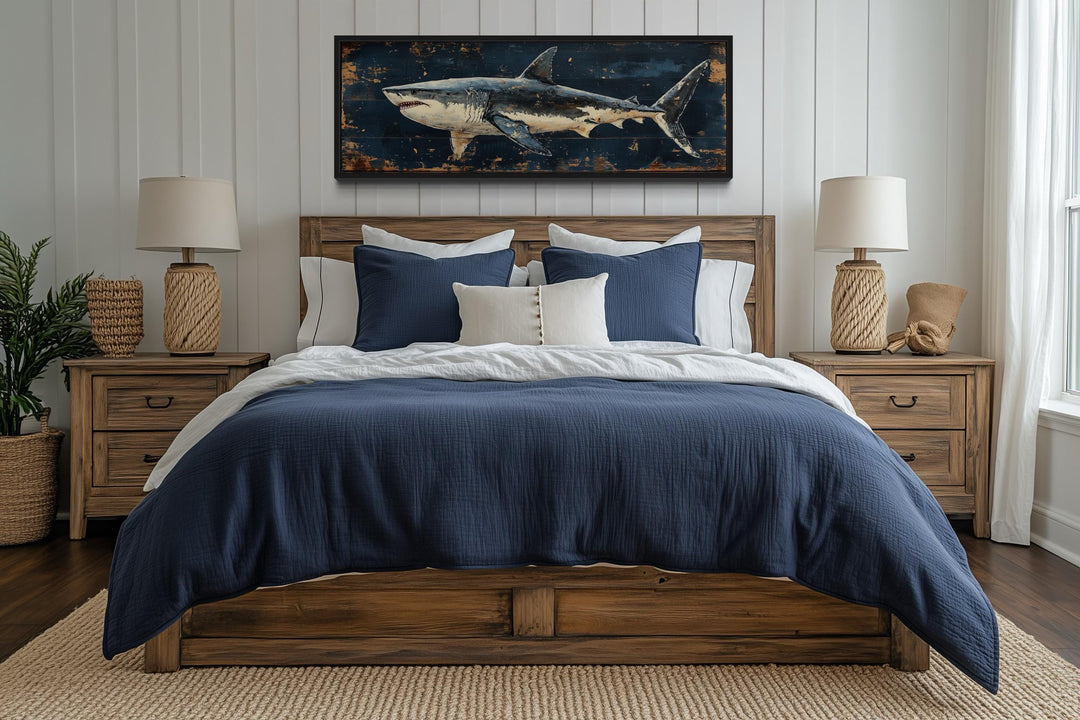 Great white shark horizontal canvas wall art hanging above a wooden bed with blue and white bedding.