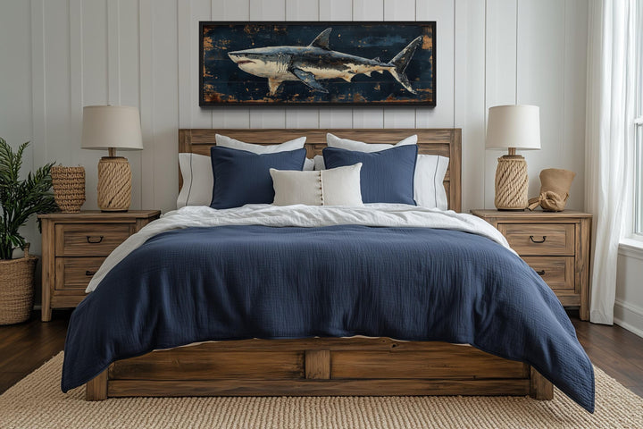Great white shark horizontal canvas wall art hanging above a wooden bed with blue and white bedding.