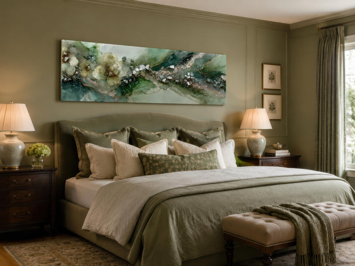 Long horizontal sage green geode canvas print with floral accents hung above a bed.