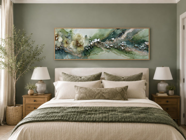 Long horizontal sage green geode canvas print with floral accents above a bed in a modern bedroom.
