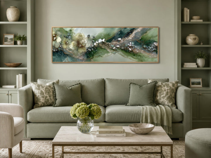 Long horizontal sage green geode and floral abstract canvas print above a green sofa.