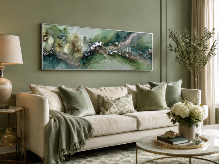 Long horizontal sage green geode and floral abstract canvas print above a cream sofa.