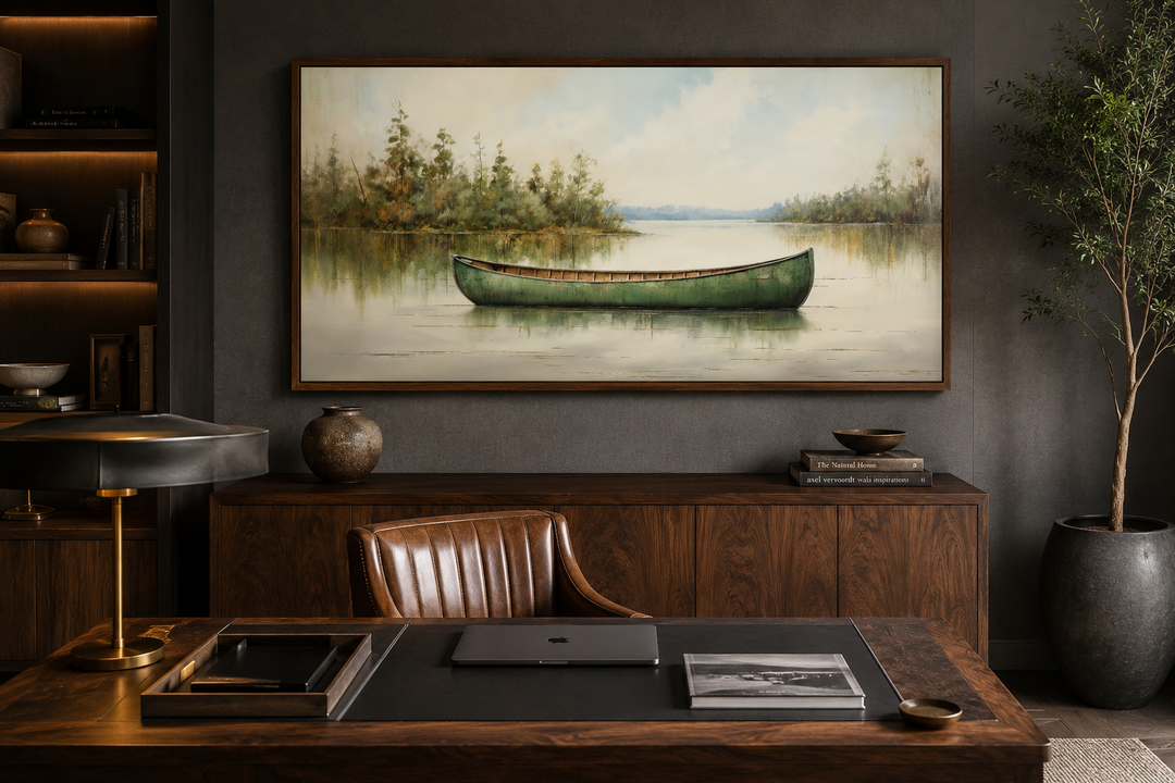 Framed wood canvas painting of a green canoe on a calm lake, styled in a rustic home office.