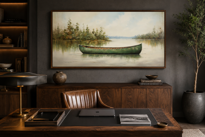 Framed wood canvas painting of a green canoe on a calm lake, styled in a rustic home office.