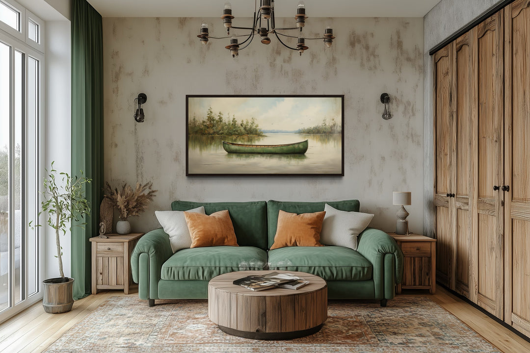 Framed green canoe wall art hanging above a green sofa in a rustic living room.