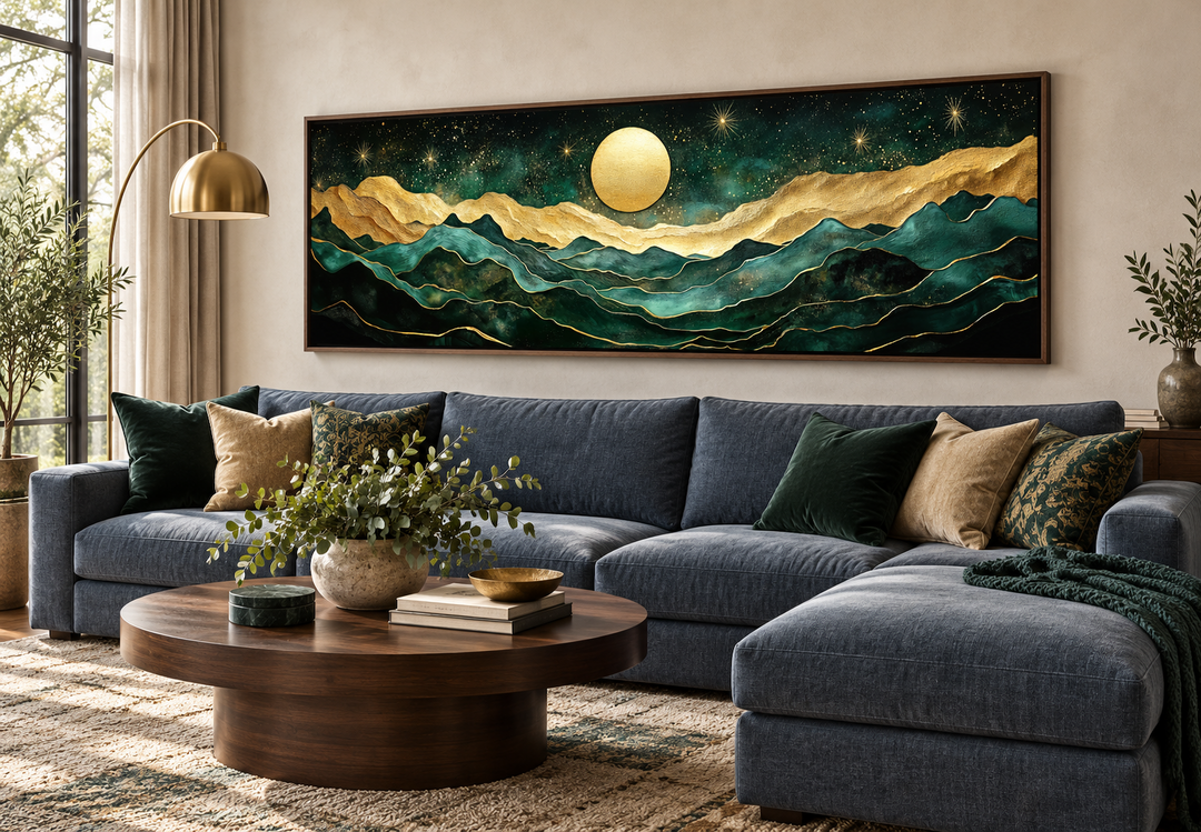 Emerald green and gold panoramic wall art of mountains and a moon above a blue sectional sofa.