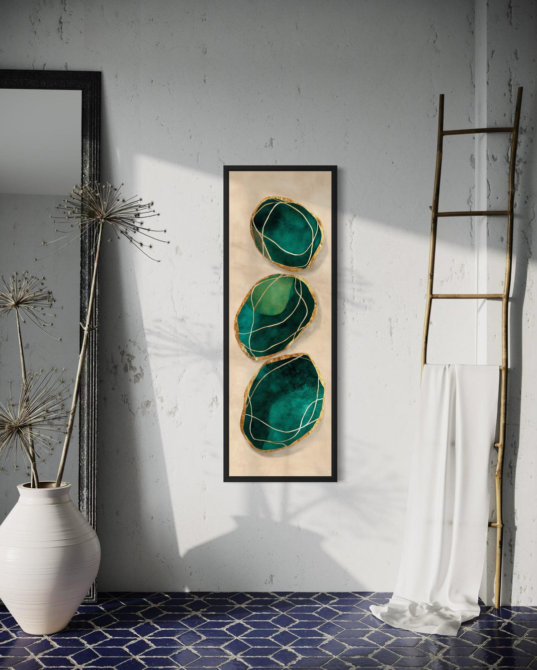 Vertical abstract canvas print featuring three emerald green stones with gold accents on a wall.
