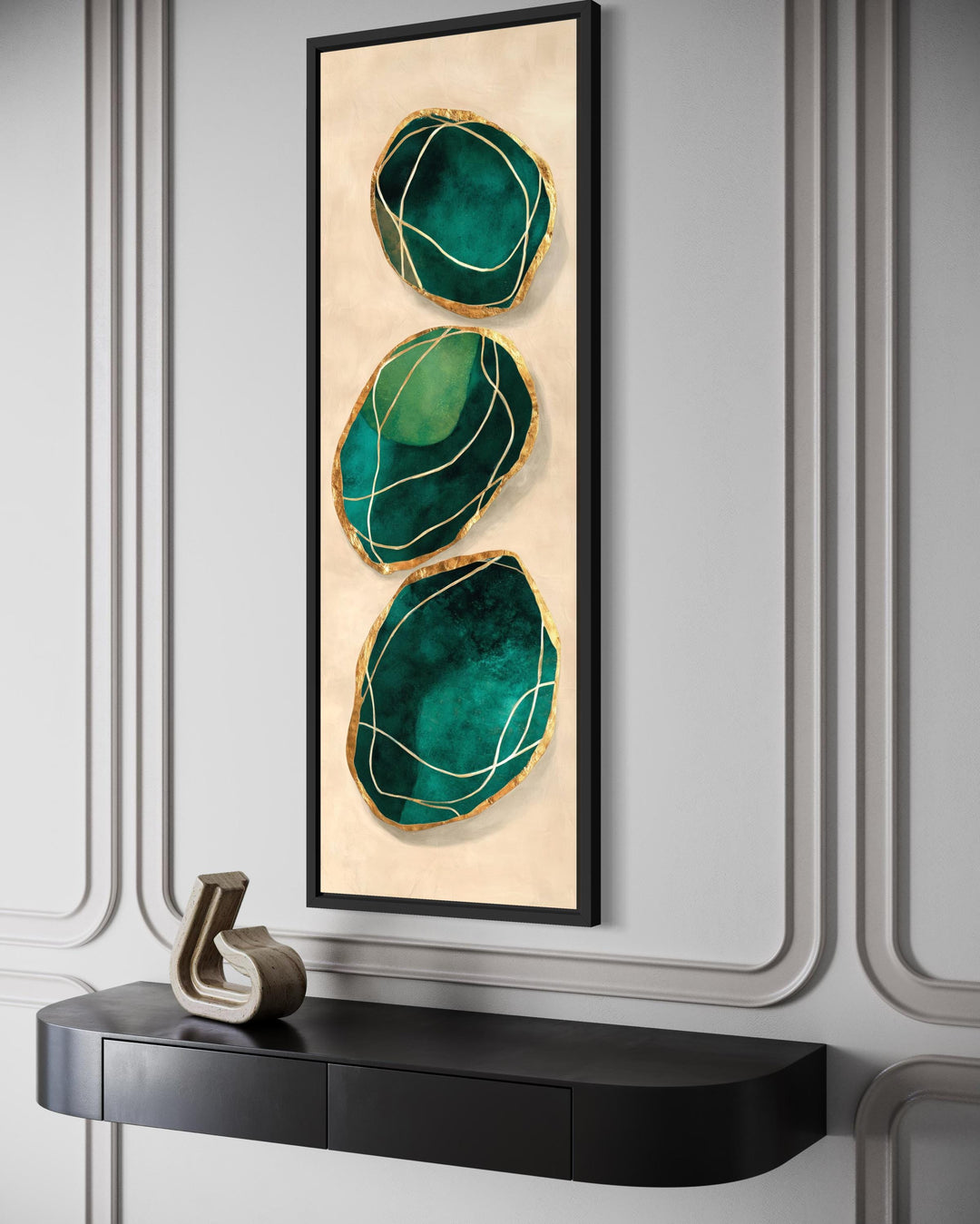 Vertical abstract canvas print featuring three emerald green and gold stones on a beige background.