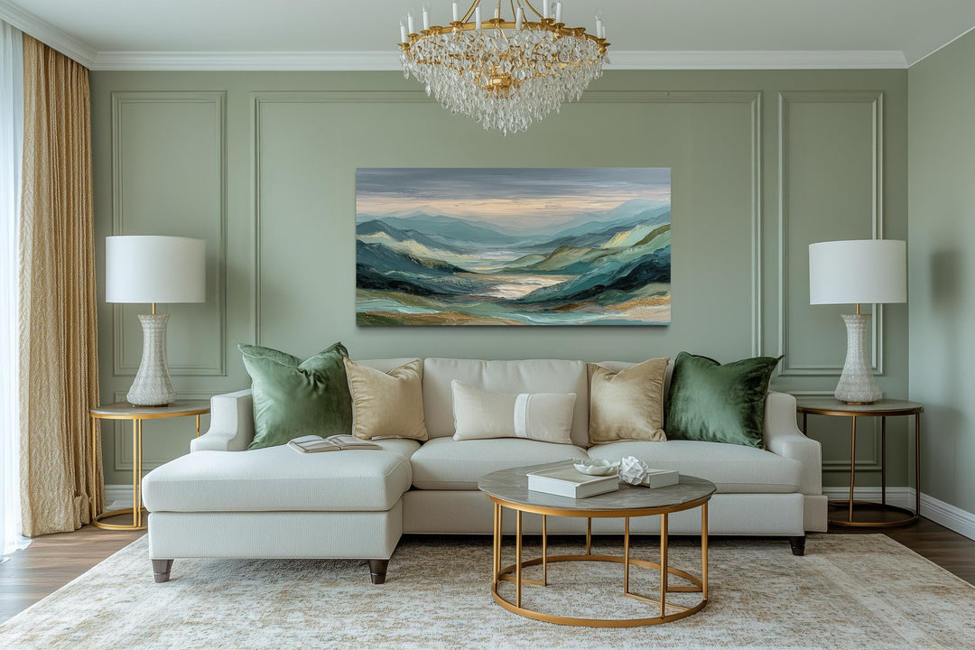 Horizontal green, grey, and gold mountain landscape wall art displayed above a modern white sofa.
