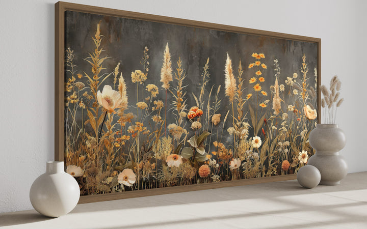Framed horizontal canvas art of boho wildflowers in grey and beige tones on a dark background.
