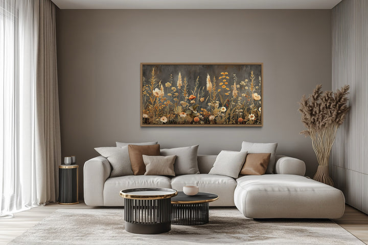 Grey beige boho wildflowers field framed canvas wall art hanging above a modern sofa in a room.