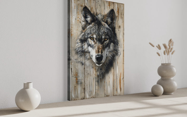 Grey wolf painting on wood-textured framed canvas wall art leaning against a white wall.