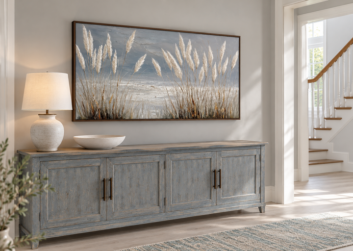 Grey boho beach grass coastal framed canvas wall art hanging above a blue wooden sideboard.