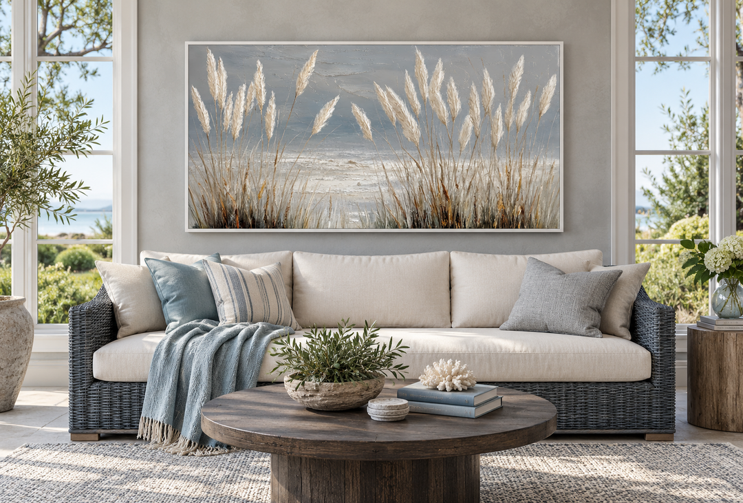 Grey boho beach grass coastal framed canvas wall art hanging above a sofa in a sunroom.