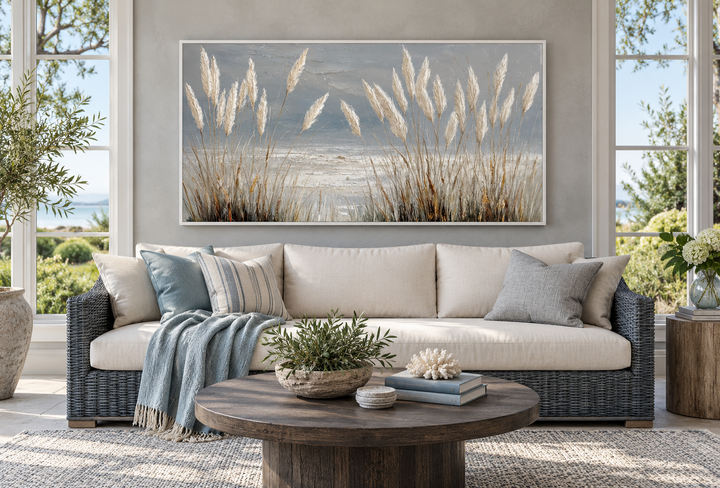 Grey boho beach grass coastal framed canvas wall art hanging above a sofa in a sunroom.
