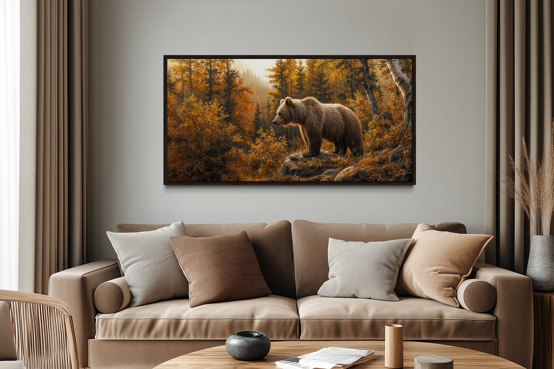 Grizzly bear in autumn forest photo-style painting canvas wall art above a tan sofa in a cabin.