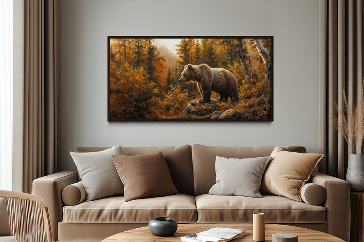 Grizzly bear in autumn forest photo-style painting canvas wall art above a tan sofa in a cabin.