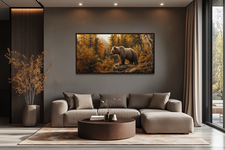 Grizzly bear in autumn forest photo-style painting canvas wall art above a modern sofa.