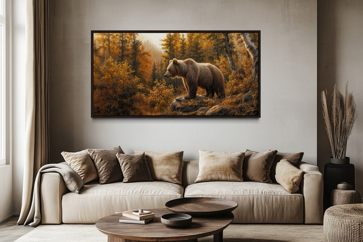 Grizzly bear in autumn forest photo-style painting canvas wall art above a beige sofa.
