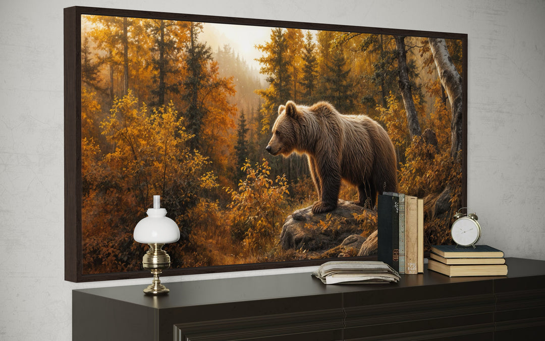 Framed canvas wall art of a grizzly bear in a golden autumn forest, displayed above a dark dresser.