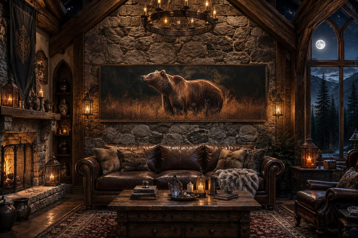 Long horizontal canvas print of a grizzly bear in golden grass above a leather sofa in a cabin.