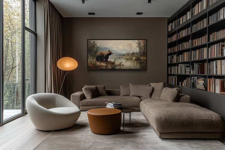 Framed grizzly bear canvas print on a dark wall in a modern living room with a brown sectional sofa.