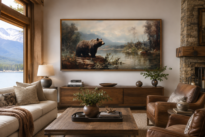 Framed grizzly bear canvas print above a wooden sideboard in a rustic living room with mountain view.